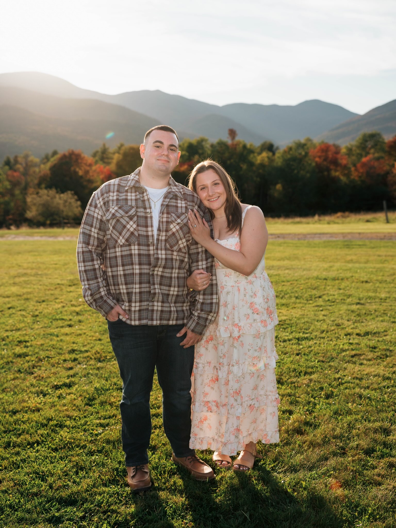 John and Erica standing together in a sunlit meadow